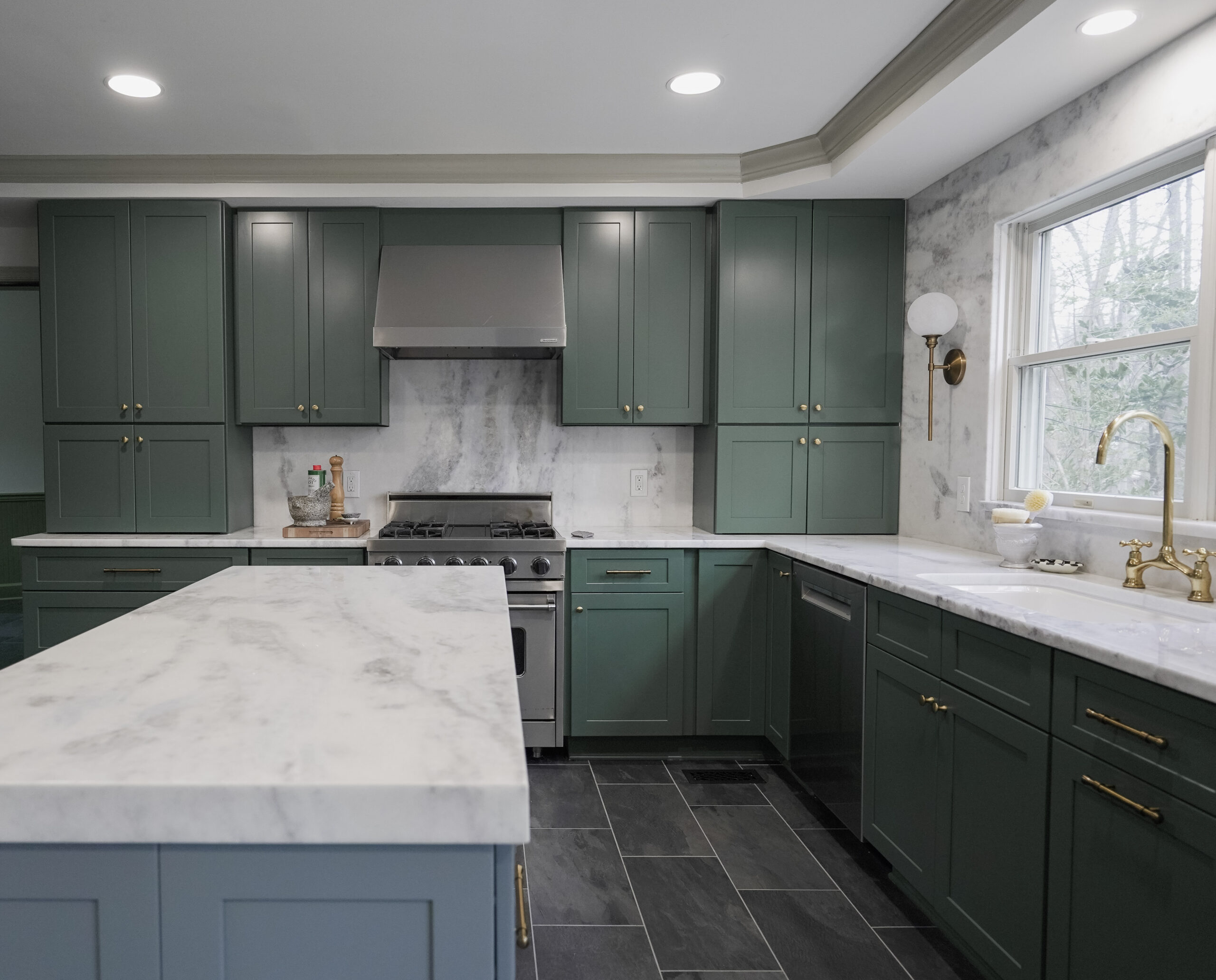 White veined quartz countertops and backsplash with green cabinetry, by GranitePro