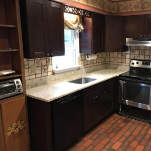 Kitchen with dark wood cabinetry and light countertops