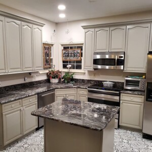 Kitchen with gray cabinetry and dark speckled countertops
