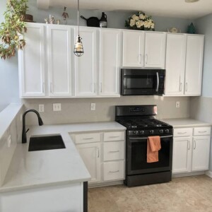 White kitchen with white countertops and stainless appliances