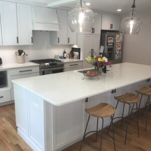 Kitchen with a white countertop island and bar stools