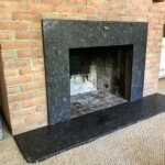 Brick fireplace with a black stone surround and hearth