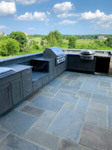 Outdoor kitchen with gray countertops and built-in grill