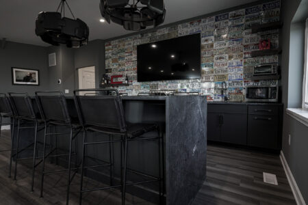 Basement bar with a dark countertop and bar stools